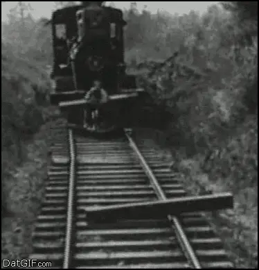 Buster Keaton in The General, riding the front of a moving locomotive with a railway sleeper in his arms